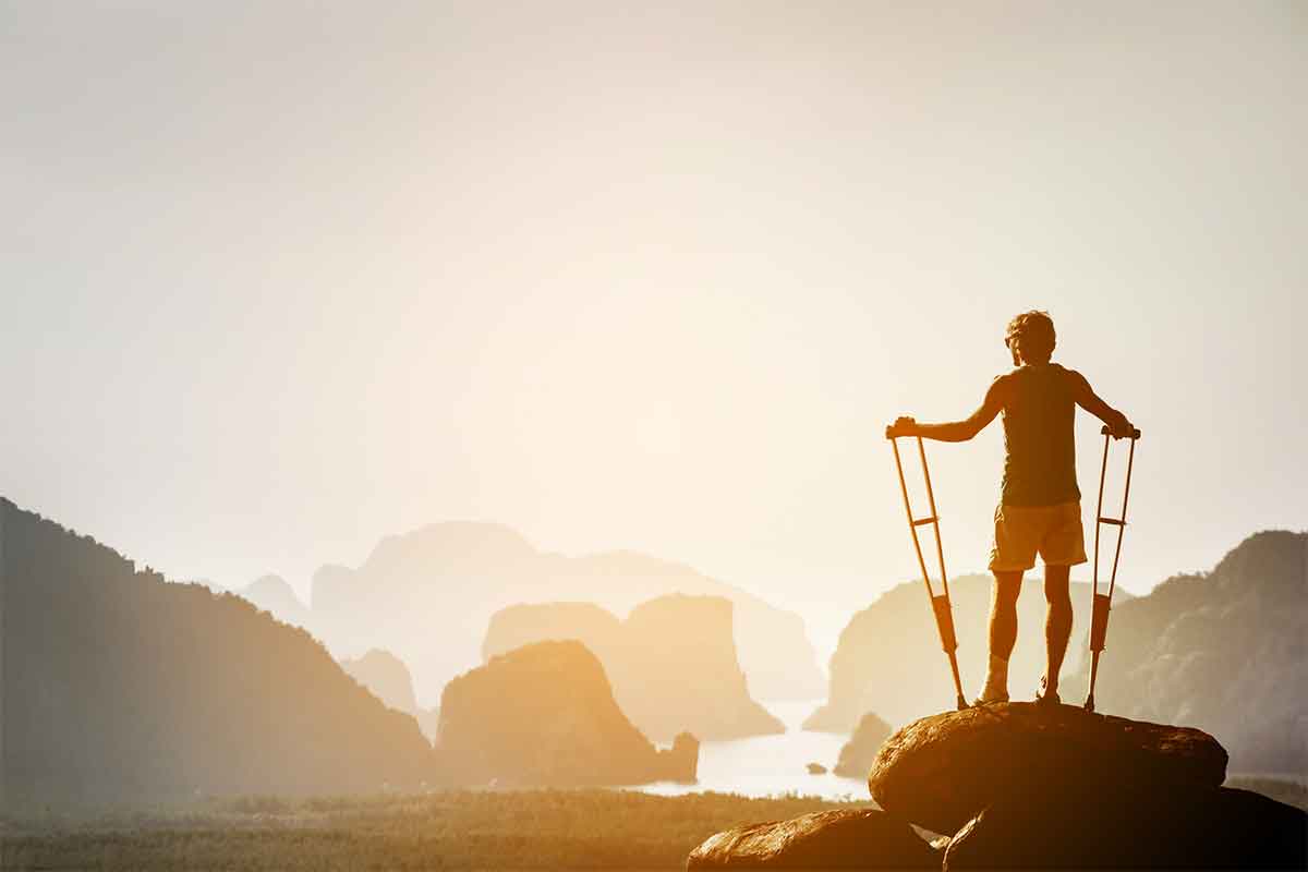 homme avec des béquilles regarant la baie d'halong